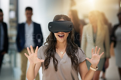 Buy stock photo Shot of a young businesswoman wearing a VR headset in a busy office