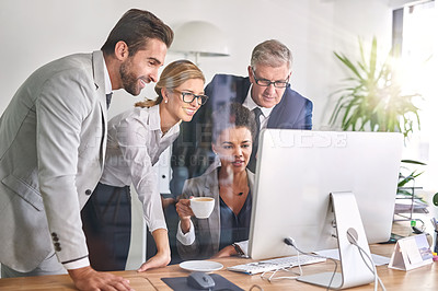 Buy stock photo Shot of businesspeople working together on a computer in an office