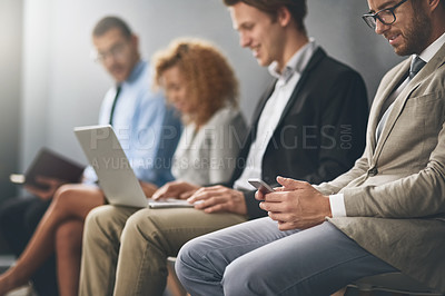 Buy stock photo Shot of a group of businesspeople waiting in line for a job interview