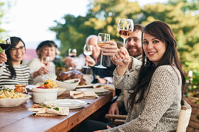 Buy stock photo Toast, dinner and family with a group of people enjoying a meal together while drinking alcohol outdoor. Portrait, party and cheers with a female and relatives bonding in festive celebration