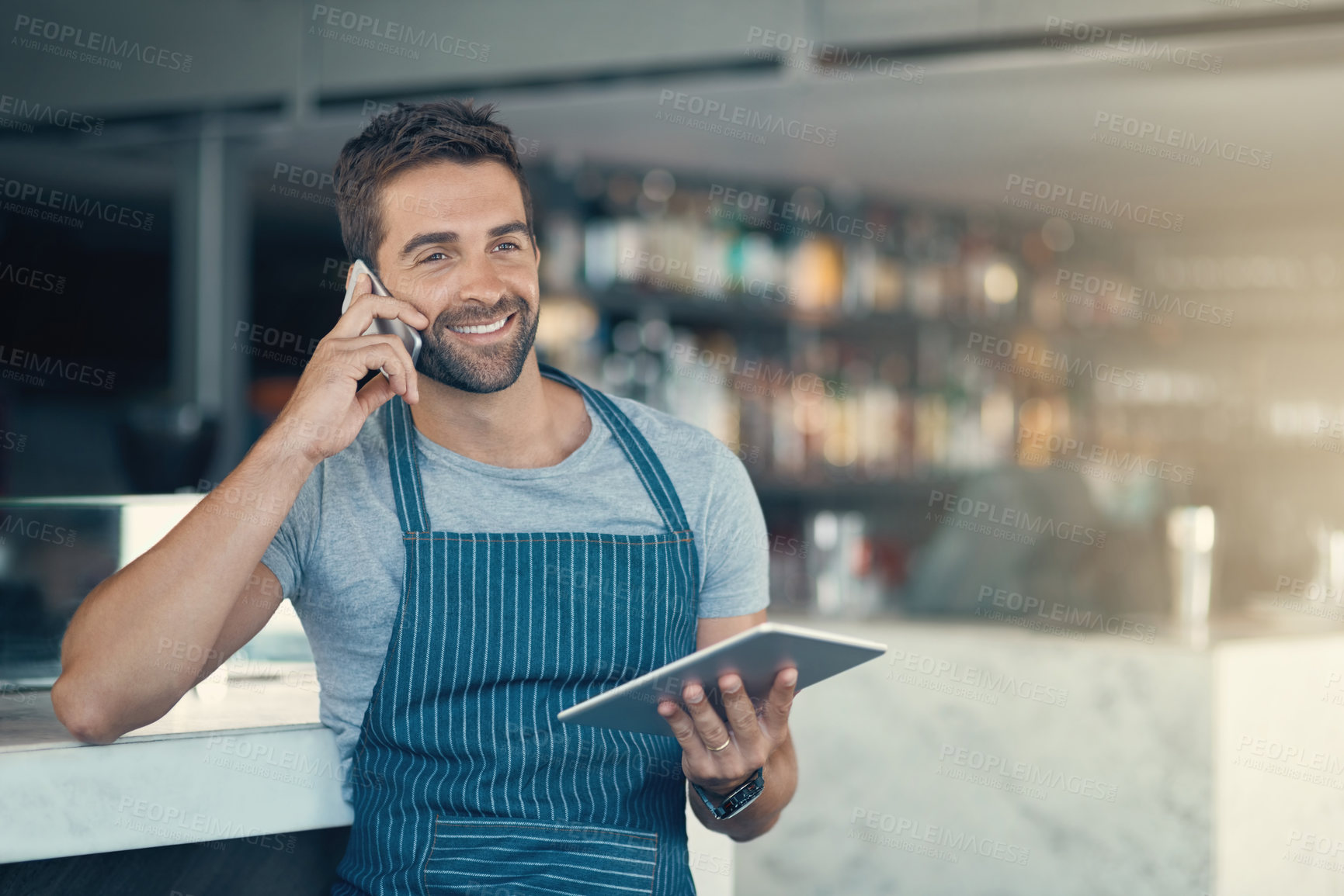 Buy stock photo Happy man, barista and phone call with tablet for online order, conversation or discussion at indoor cafe. Male person or waiter talking with smile or technology on mobile smartphone for reservation