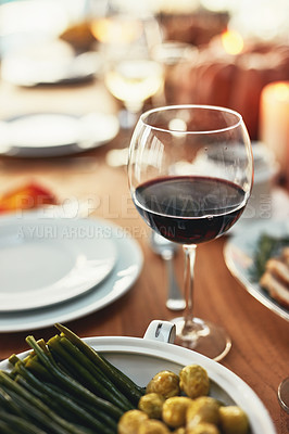 Buy stock photo Closeup, glass and wine on table at dinner, restaurant or house for celebration, holiday or party. Red wine, alcohol and vegetables in dining room for thanksgiving, Christmas or fine dining in home
