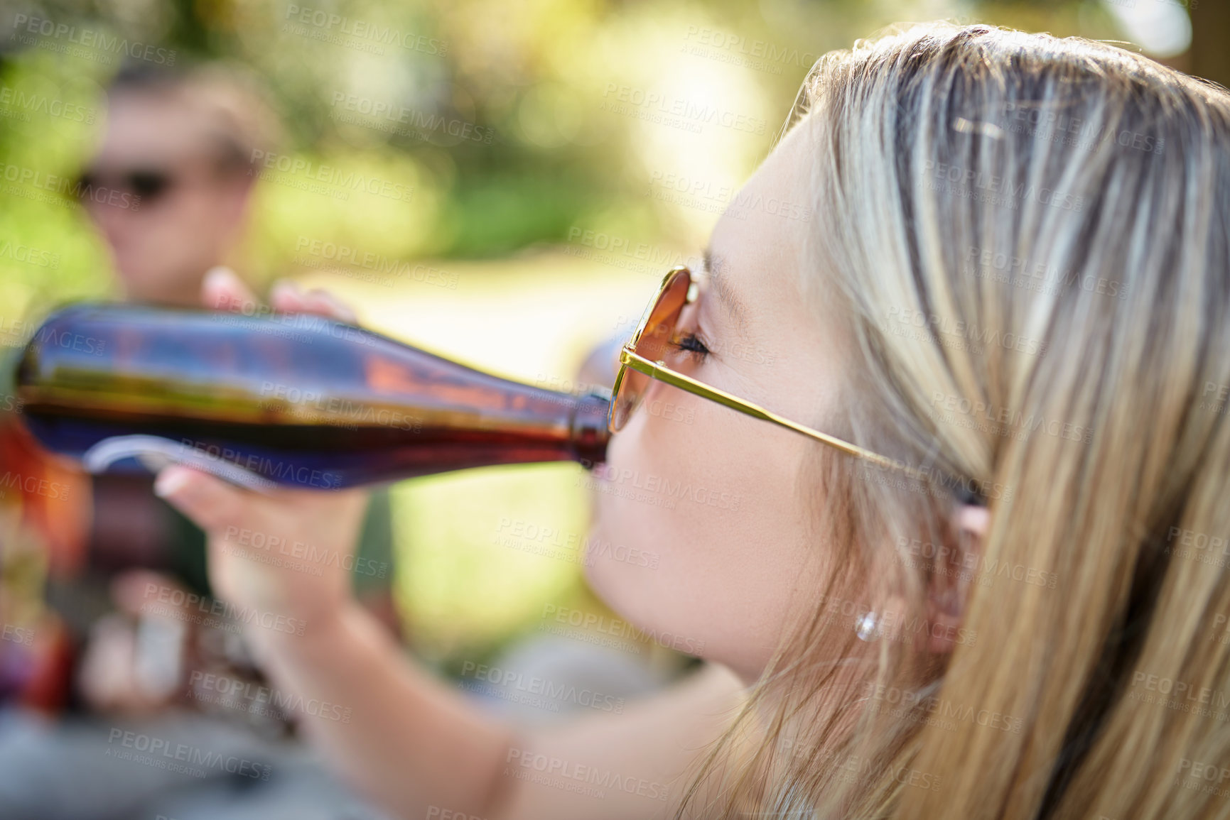 Buy stock photo Cropped shot of an attractive young woman enjoying a few drinks with friends outside in the summer sun