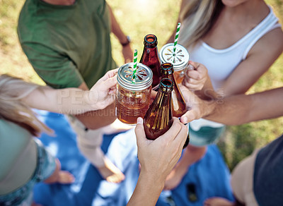 Buy stock photo High angle shot of a young group of friends toasting while enjoying a few drinks outside in the summer sun