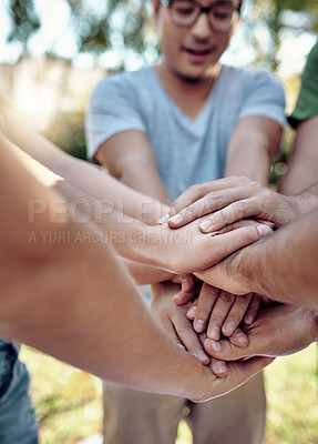 Buy stock photo Cropped shot of a young group of friends standing outside with their hands in a huddle