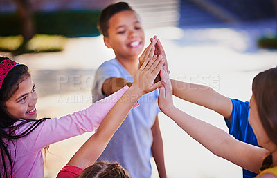 Buy stock photo Shot of a diverse group of children giving each other a high five outside