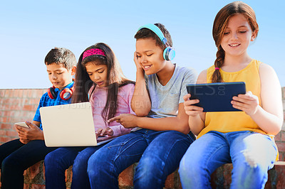 Buy stock photo School kids, friends and happy with phone, tablet and laptop with diversity, relax and streaming in summer. Girl, boy and group with headphones, smile and games with subscription on wall at academy