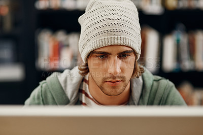 Buy stock photo High angle shot of a young male university student studying in the library