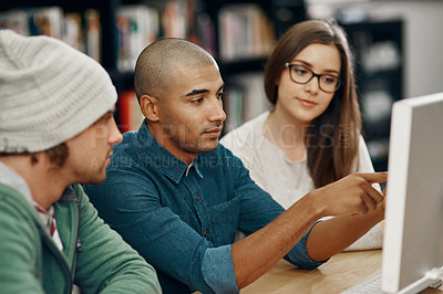 Buy stock photo Cropped shot of three young university students studying in the library