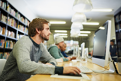 Buy stock photo Cropped shot of a young male university student studying in the library
