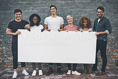 Buy stock photo Shot of a diverse group of people holding up a placard outside