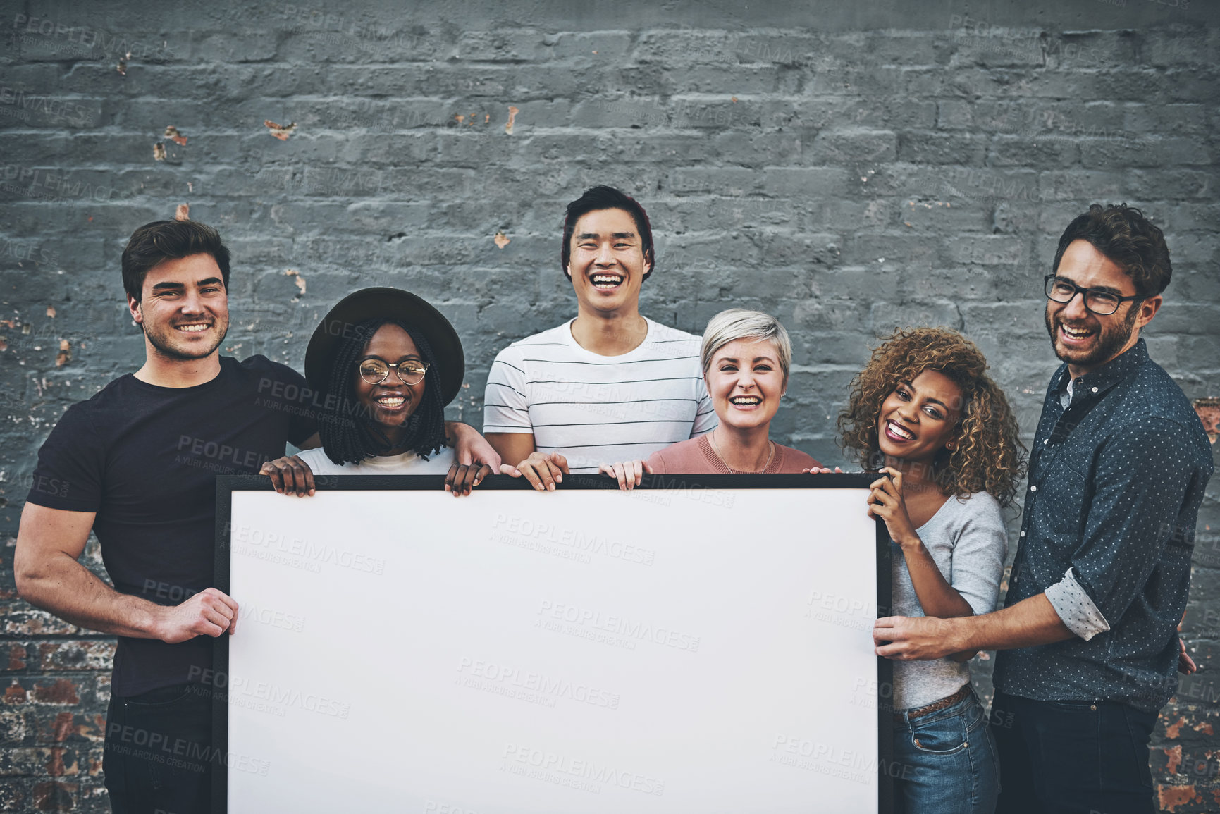 Buy stock photo Shot of a diverse group of people holding up a placard outside