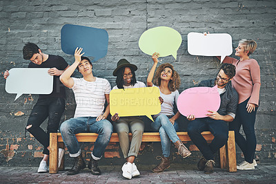 Buy stock photo Shot of a diverse group of people holding up speech bubbles outside