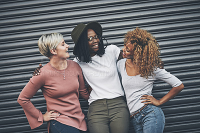 Buy stock photo Shot of a diverse group of female friends embracing each other outside
