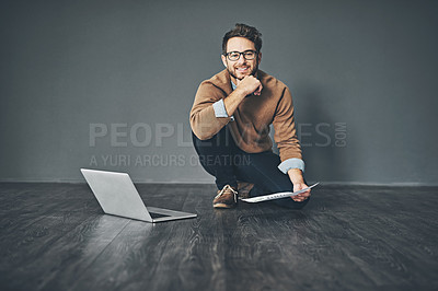 Buy stock photo Studio portrait of a young businessman working on a laptop against a grey background