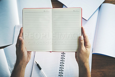Buy stock photo High angle shot of an unrecognisable person sitting with blank notebooks at a desk