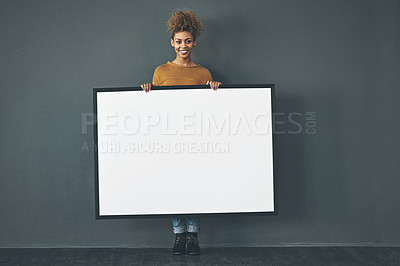 Buy stock photo Studio portrait of a young woman holding a blank sign against a grey background