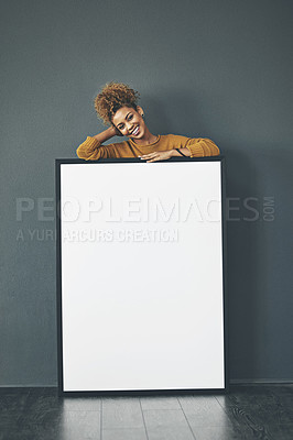 Buy stock photo A beautiful confident woman holding a blank whiteboard or billboard sign with copy space. Happy and attractive female with a smile standing behind a banner. Young lady advertising with a poster