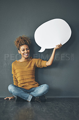 Buy stock photo Studio portrait of a young woman holding a speech bubble against a grey background