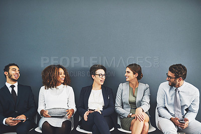 Buy stock photo Studio shot of a group of businesspeople talking while waiting in line against a gray background
