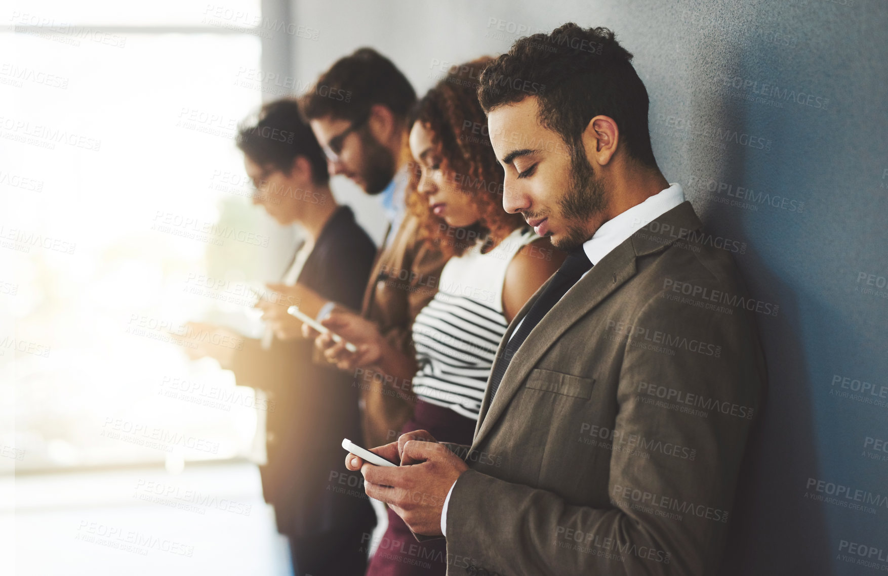 Buy stock photo Cropped shot of businesspeople using their cellphones while standing in a row