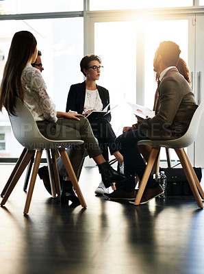 Buy stock photo Shot of a group of corporate businesspeople sitting in a meeting