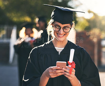 Buy stock photo Shot of a young woman using a mobile phone on graduation day