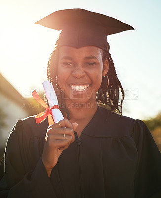 Buy stock photo Portrait of a happy young woman holding a diploma on graduation day