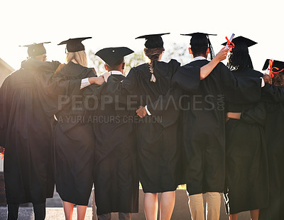 Buy stock photo Rearview shot of a group of university students standing outside on graduation day