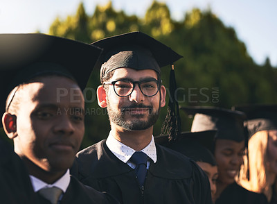 Buy stock photo Portrait of a smiling university student on graduation day with classmates in the background