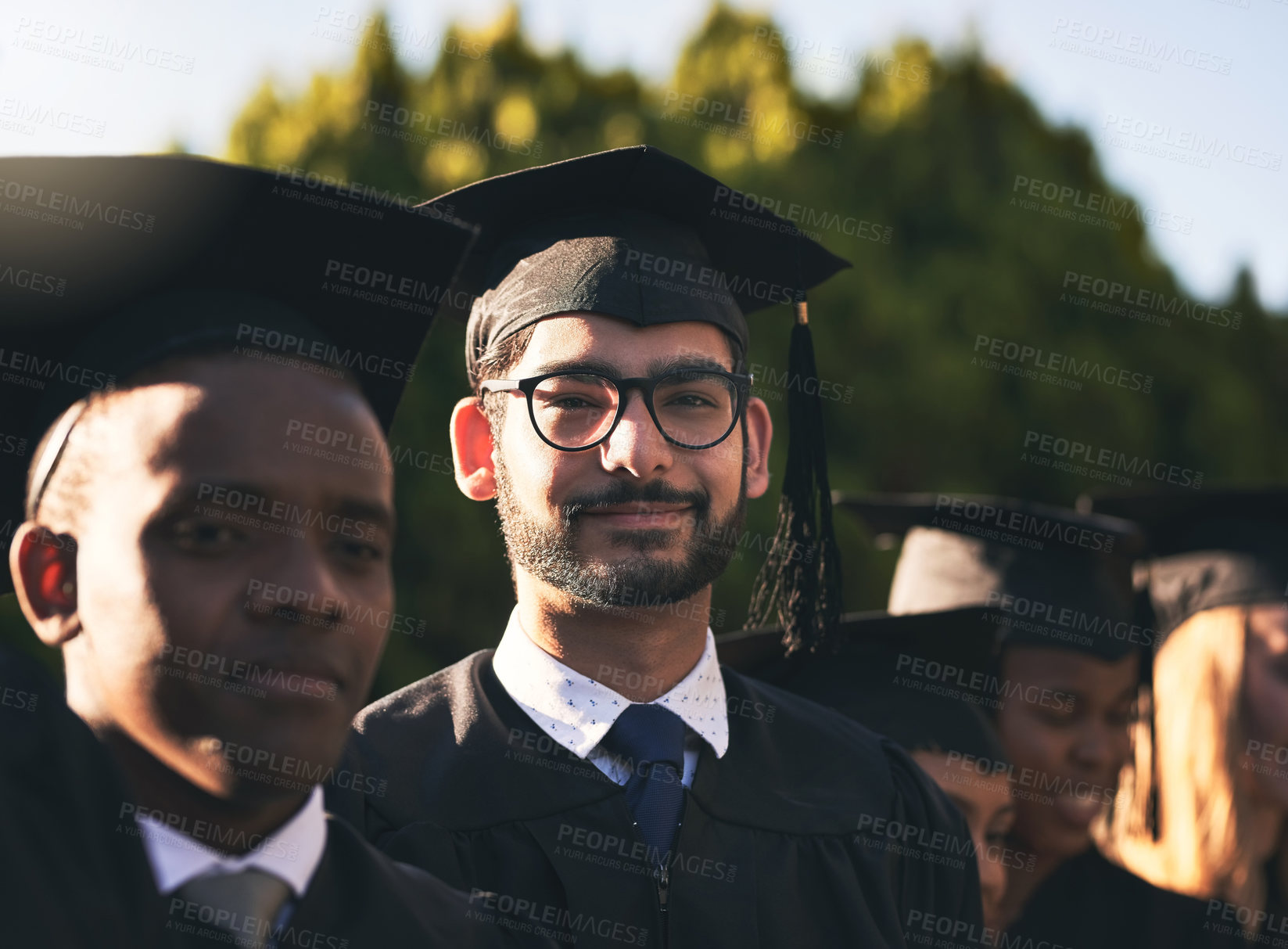 Buy stock photo Celebration, graduation and portrait of student man outdoor on campus with friends for ceremony or event. Education, face and smile with happy graduate person at college or university for success