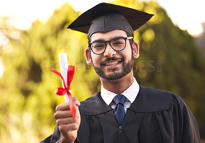 Buy stock photo Portrait of a happy young man holding a diploma on graduation day