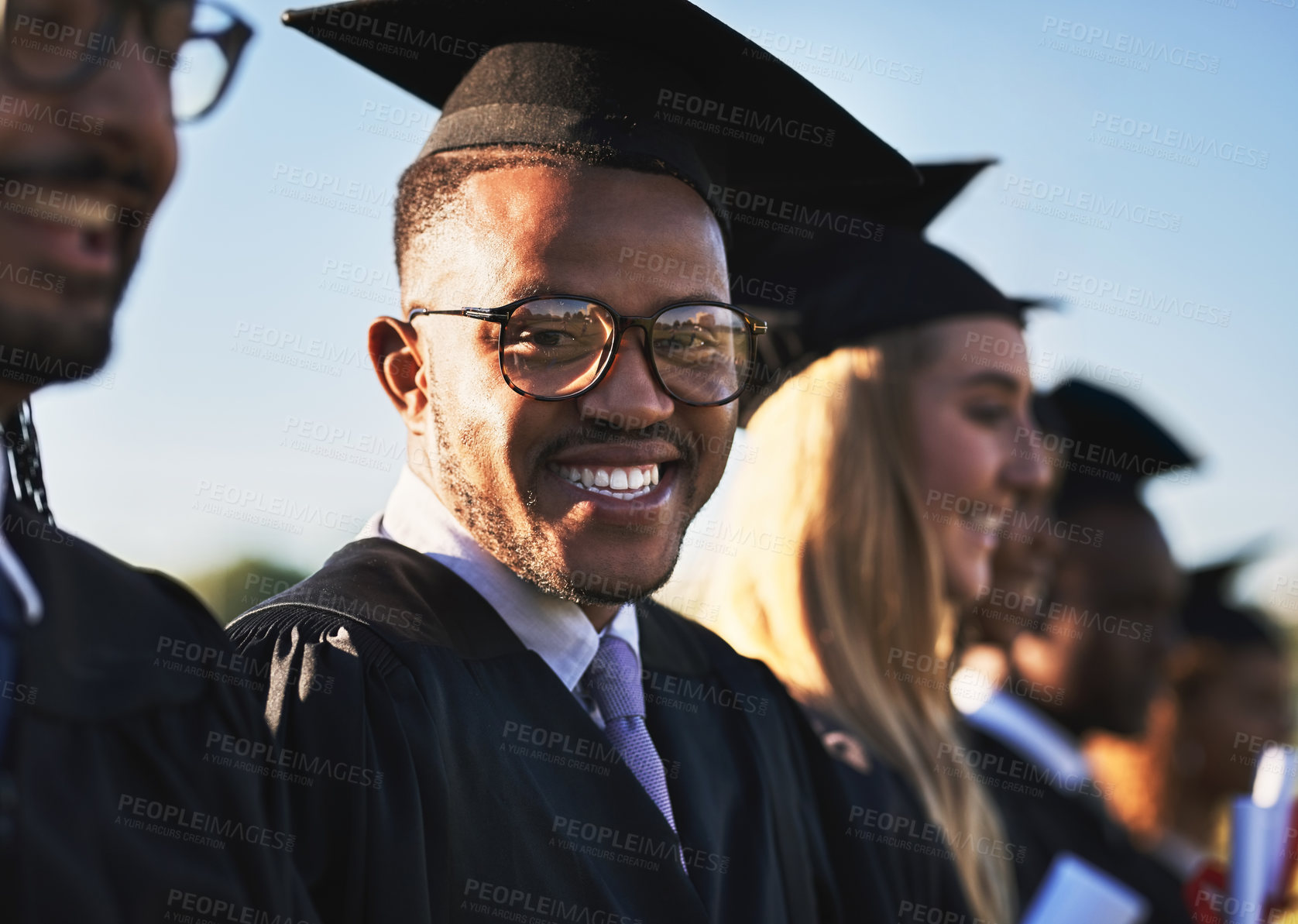 Buy stock photo Black man, students portrait and graduation ceremony with class group for education, qualification or future. Face of person or scholar with smile for diploma, certificate or degree on campus