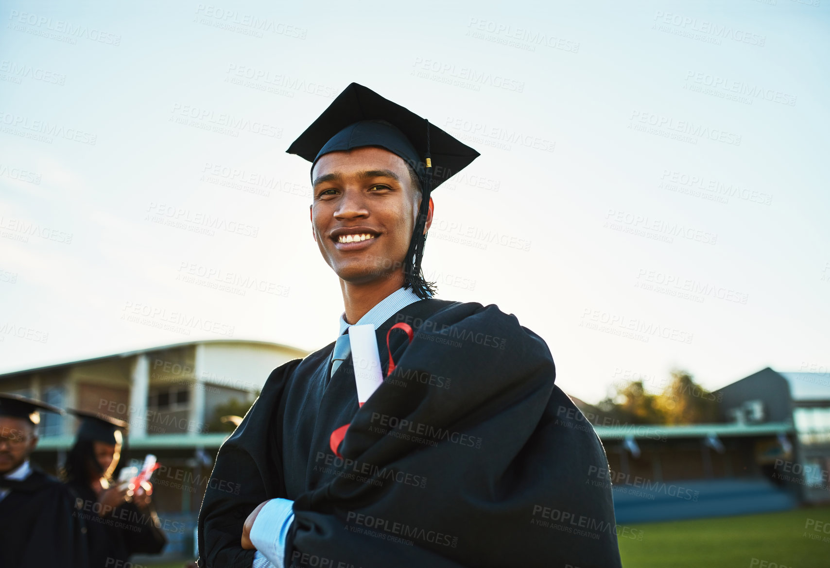 Buy stock photo Portrait, graduate and happy man with arms crossed at university outdoor for success, milestone or future career. Face, smile and student at graduation with confidence, pride or education certificate