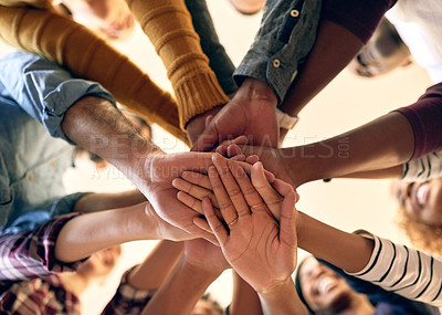 Buy stock photo Low angle shot of a group of people joining their hands together