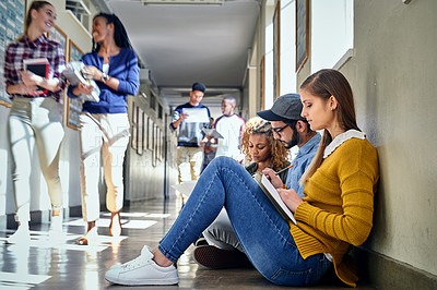 Buy stock photo Full length shot of a group of young students studying in the university corridor