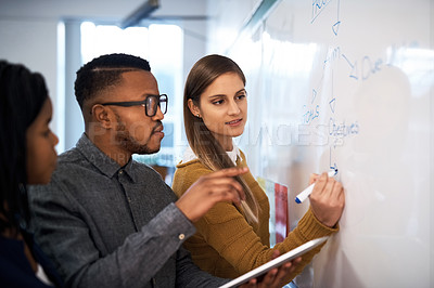 Buy stock photo Shot of a group of students brainstorming at a whiteboard in class