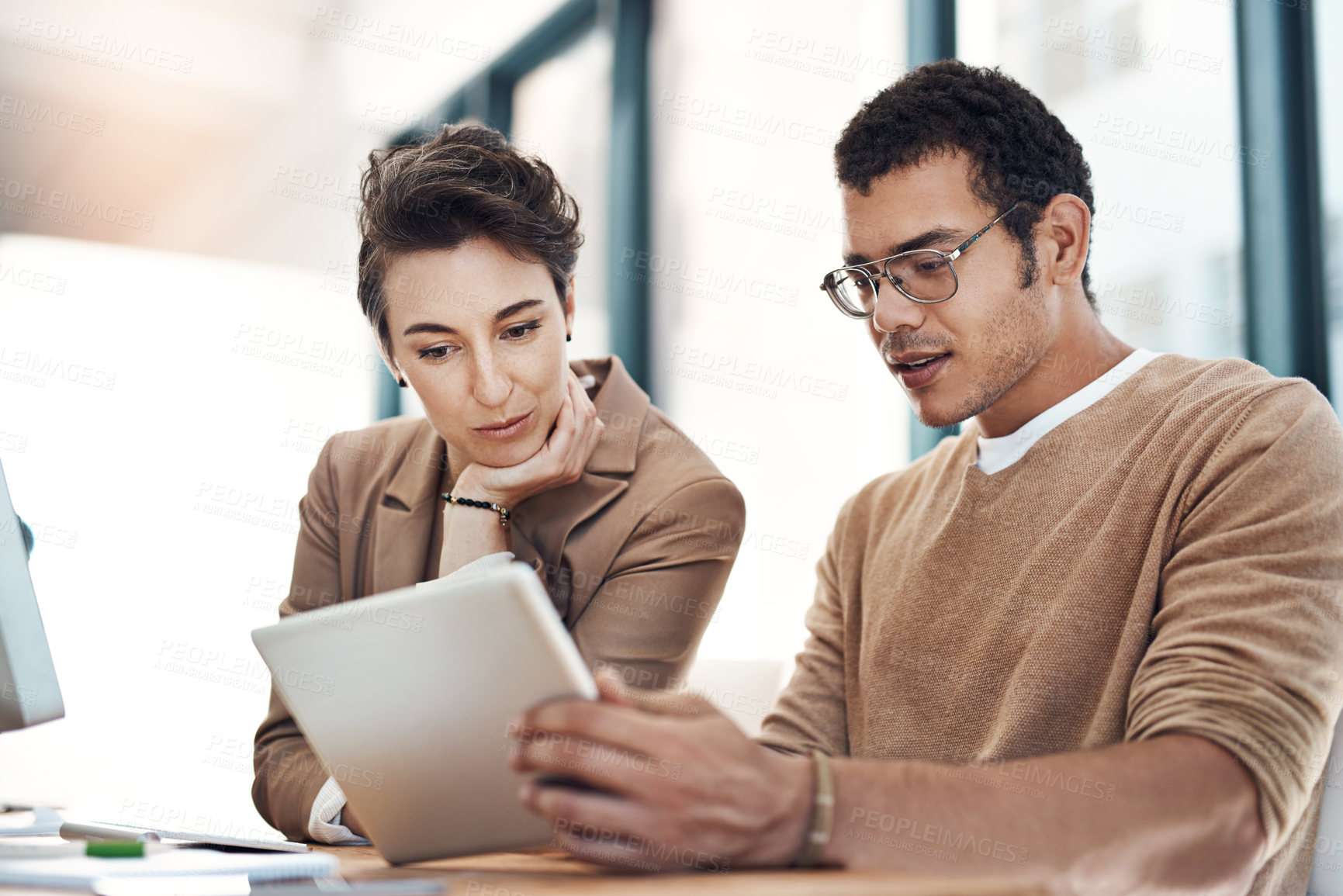 Buy stock photo Shot of two businesspeople working together on a digital tablet in an office