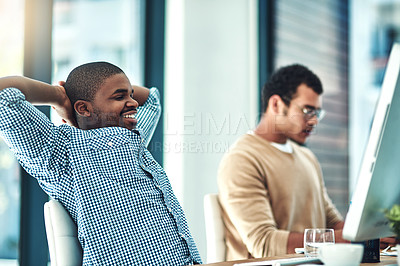 Buy stock photo Shot of a young designer looking relaxed at his desk