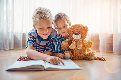 Buy stock photo Little boy, brother and reading with book on floor for fairy tale, story or novel together at home. Child, kid or siblings with notebook, teddy bear or toy for fun learning, education or literature