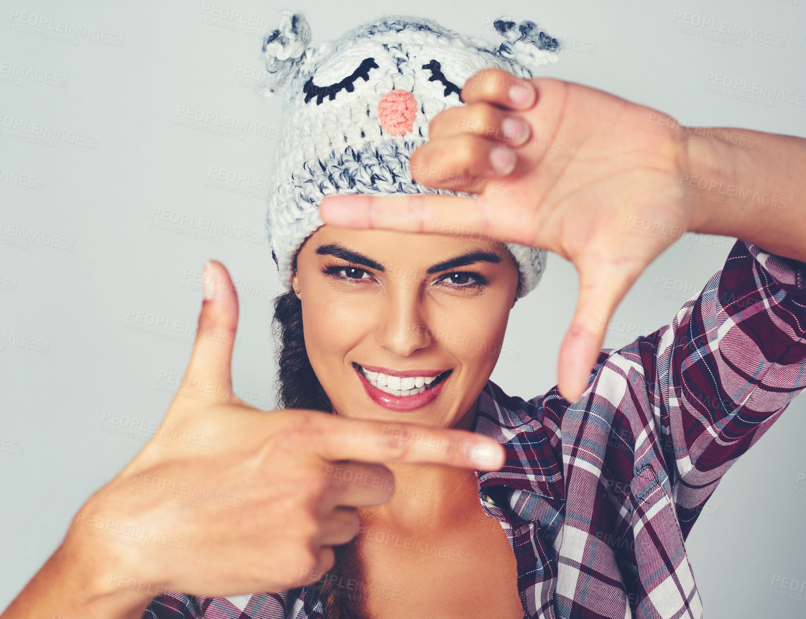 Buy stock photo Cropped shot of a young woman posing with a character beanie