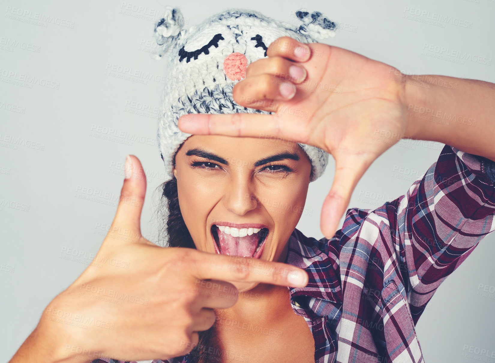 Buy stock photo Cropped shot of a young woman posing with a character beanie