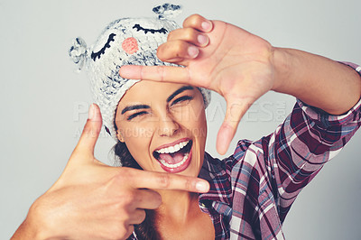 Buy stock photo Cropped shot of a young woman posing with a character beanie