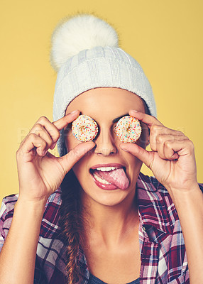 Buy stock photo Cropped shot of a young woman covering her eyes with cookies against a colorful background
