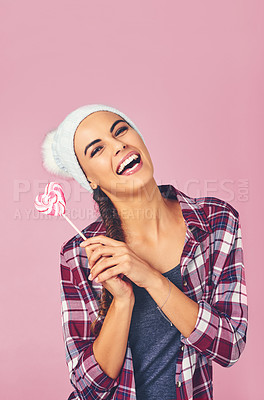 Buy stock photo Shot of a young woman holding a heart-shaped lollipop against a colorful background
