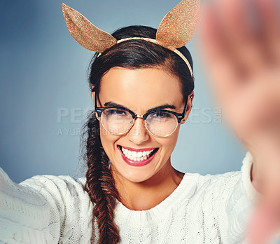 Buy stock photo Woman, portrait and costume with selfie of ears in studio for playful style, fashion and social media. Female person, happy and digital photography with outfit for halloween post by blue background