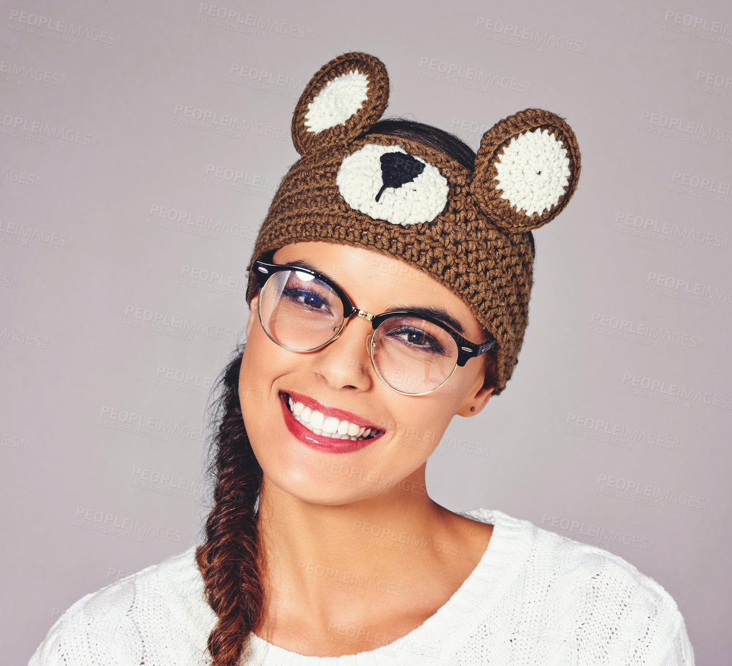 Buy stock photo Studio, happy woman and portrait with beanie for fashion, winter outfit or teddy bear style with pride. Female person, glasses and trendy with smile for Crochet headband, wool hat or white background