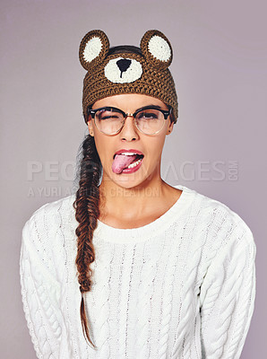 Buy stock photo Studio, woman and portrait with tongue out for fashion, winter outfit and teddy bear beanie for style. Female person, playful and emoji with trendy for crochet headband, wool and isolated background