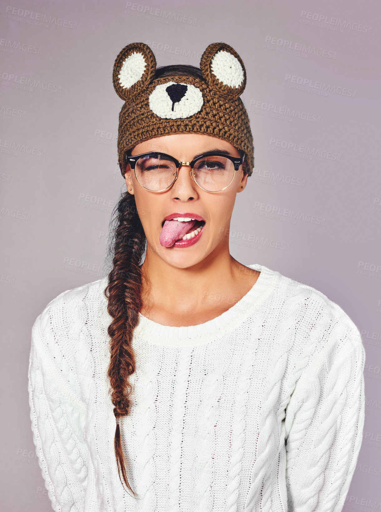 Buy stock photo Studio, woman and portrait with tongue out for fashion, winter outfit and teddy bear beanie for style. Female person, playful and emoji with trendy for crochet headband, wool and isolated background