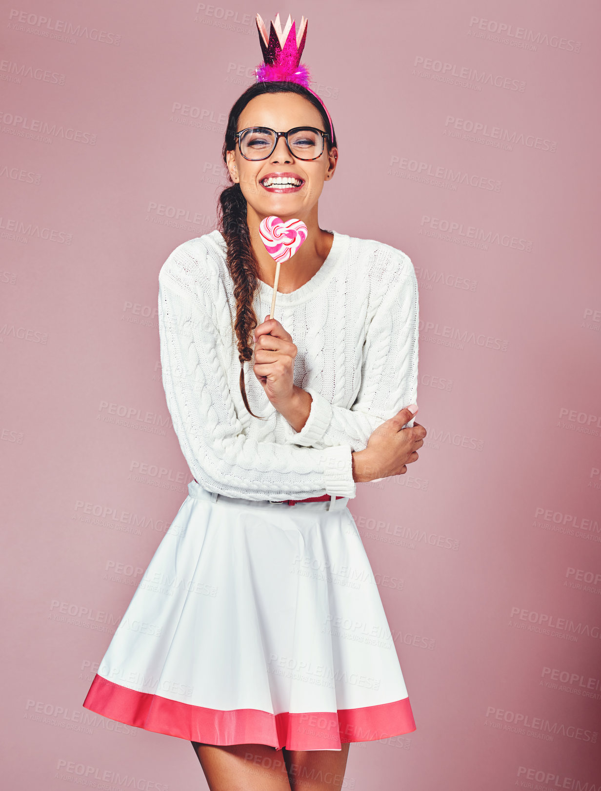 Buy stock photo Happy, portrait and woman with lollipop in studio for sweet snack, costume and stylish fashion. Female person, smile and crown with candy by pink background for halloween treat, colorful and clothes